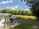 Patio area with outdoor dining furniture and a grill, overlooking a pond at 461 Misty Law Ln, Clover, SC 29710