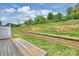 Spacious backyard features a retaining wall, grass, wooden deck, and fencing at 502 Tayberry Ln, Fort Mill, SC 29715