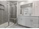 Modern bathroom featuring a double vanity, grey tiled shower, and glass doors at 502 Tayberry Ln, Fort Mill, SC 29715