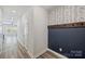 Hallway featuring stylish wallpaper accent wall, coat hooks, durable wood-look flooring, and bright lighting at 502 Tayberry Ln, Fort Mill, SC 29715