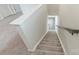 Carpeted staircase with white walls and railing, leading to upper level with hardwood flooring at 502 Tayberry Ln, Fort Mill, SC 29715