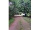 Long driveway leading to a charming house with a covered front porch surrounded by mature trees at 5023 Dogwood Ln, Stanley, NC 28164