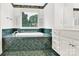 Bright bathroom featuring a large tiled garden tub, vanity with storage and a shuttered window at 511 Brookwood Dr, Statesville, NC 28677