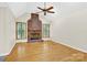 Inviting living room with hardwood floors, large brick fireplace, and shuttered windows at 511 Brookwood Dr, Statesville, NC 28677