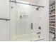 Bright bathroom featuring tiled walls, sleek fixtures, and a glass-enclosed shower-over-tub setup at 5114 Leisure Ln, Sherrills Ford, NC 28673
