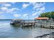 Picturesque lakeside scene featuring a dock and boat house under a blue sky with scattered clouds at 5114 Leisure Ln, Sherrills Ford, NC 28673