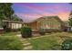 Brick home features a sunroom addition, lush landscaping, and a beautiful yard at 5114 Leisure Ln, Sherrills Ford, NC 28673