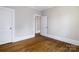 Bedroom featuring hardwood floors, white trim, and two doors, creating an open and inviting space at 524 Hawthorne Ln, Charlotte, NC 28204