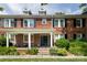 Charming brick townhouse with a welcoming front porch, complemented by black shutters and lush greenery at 524 Hawthorne Ln, Charlotte, NC 28204
