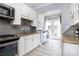 Bright kitchen with granite countertops, stainless appliances, grey backsplash and washer/dryer unit at 524 Hawthorne Ln, Charlotte, NC 28204