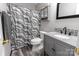 Bathroom with white toilet and sink with gray cabinet, mirror, and patterned shower curtain at 532 Jedburgh Way, Rock Hill, SC 29730