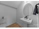 Elegant powder room with a pedestal sink, modern fixtures, and minimalist design at 6032 Corbin Woods Ct, Charlotte, NC 28226