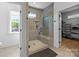 Modern bathroom featuring a glass-enclosed shower with a built-in bench and adjacent walk-in closet at 6032 Corbin Woods Ct, Charlotte, NC 28226
