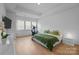 Bright primary bedroom with hardwood floors, tray ceiling, and a sitting area at 6032 Corbin Woods Ct, Charlotte, NC 28226