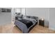 Modern bedroom showcasing hardwood floors, a queen-size bed, a work station, and a nightstand at 6032 Corbin Woods Ct, Charlotte, NC 28226