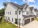 Side view of a modern home with white siding, black roof, and well-manicured lawn at 6032 Corbin Woods Ct, Charlotte, NC 28226
