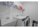 Bright laundry room with modern washer and dryer, utility sink, and ample shelving for storage at 6032 Corbin Woods Ct, Charlotte, NC 28226