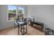 Bright home office featuring a modern glass desk, ample natural light, and wood floors at 6032 Corbin Woods Ct, Charlotte, NC 28226
