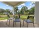 Covered patio with three chairs offering a serene view of the well-maintained fenced backyard at 6032 Corbin Woods Ct, Charlotte, NC 28226