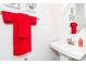 Contemporary bathroom with a pedestal sink, a round mirror, and bright red towels for a pop of color at 628 Uwharrie River Rd, Charlotte, NC 28211