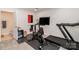 Bright workout room with treadmill, stationary bike, mounted television, and beverage cooler at 628 Uwharrie River Rd, Charlotte, NC 28211