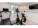 Bright exercise room featuring a treadmill, stationary bike, television, and sliding glass doors to the outside at 628 Uwharrie River Rd, Charlotte, NC 28211
