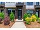 Inviting front entrance with a black front door, manicured bushes, decorative rock and a concrete walkway at 628 Uwharrie River Rd, Charlotte, NC 28211