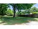 Lush backyard with mature trees, a wooden fence, and a glimpse of a shed at 639 S Eastway Dr, Troutman, NC 28166
