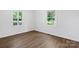 Bedroom with wood floors features neutral paint and two windows allowing natural light at 639 S Eastway Dr, Troutman, NC 28166