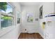 Bright laundry room featuring wood floors, updated windows, and a modern water heater setup at 639 S Eastway Dr, Troutman, NC 28166