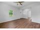Living room with wood floors features neutral paint, a ceiling fan, and natural light at 639 S Eastway Dr, Troutman, NC 28166