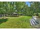 Spacious backyard with lush green grass, mature trees, and a wooden deck for outdoor enjoyment at 6409 Ilex Ct, Charlotte, NC 28211