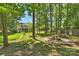 Expansive backyard with a fire pit area, mature trees, and a view of the home at 6409 Ilex Ct, Charlotte, NC 28211