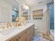 Bathroom featuring double sinks, designer tile floor, soaking tub, and natural light at 6409 Ilex Ct, Charlotte, NC 28211