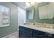 Bathroom featuring double sinks, marble countertops, gold fixtures, and a glass-enclosed shower at 6409 Ilex Ct, Charlotte, NC 28211