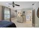 Bright bedroom featuring a ceiling fan, neutral walls, large window, and stylish decor at 6409 Ilex Ct, Charlotte, NC 28211