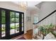 Bright foyer with a stylish light fixture and hardwood flooring leading to the staircase at 6409 Ilex Ct, Charlotte, NC 28211