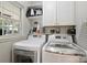 Bright laundry area with washer, dryer, storage cabinets, and natural light at 6409 Ilex Ct, Charlotte, NC 28211