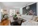 Bright living room with large floral accent wall, hardwood floors, and cozy seating at 6409 Ilex Ct, Charlotte, NC 28211