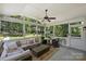 Screened porch featuring comfortable seating, ceiling fan, and views of the backyard at 6409 Ilex Ct, Charlotte, NC 28211