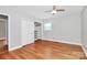 Bright bedroom boasts hardwood floors, ceiling fan, and a closet with ample shelving at 6908 Lancer Dr, Charlotte, NC 28226