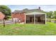 Brick home with covered porch, two-car garage and fenced yard with lush green grass at 6908 Lancer Dr, Charlotte, NC 28226