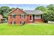 Charming brick home with a well-maintained lawn and a bright red front door at 6908 Lancer Dr, Charlotte, NC 28226