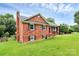 Classic brick home with a chimney and manicured lawn in a suburban setting at 6908 Lancer Dr, Charlotte, NC 28226