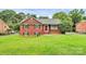 Quaint brick home featuring classic architectural details, manicured lawn, and inviting front entrance at 6908 Lancer Dr, Charlotte, NC 28226