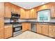 Bright kitchen featuring stainless appliances, stylish backsplash, and wooden cabinets at 6908 Lancer Dr, Charlotte, NC 28226