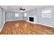 The spacious living room features wood-look floors and a brick fireplace at 6908 Lancer Dr, Charlotte, NC 28226