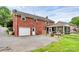 Back exterior showcasing a brick facade, attached garage, and screened-in porch overlooking the backyard at 6908 Lancer Dr, Charlotte, NC 28226