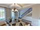Elegant dining room featuring decorative lighting, a large window, and staircase in the background at 7101 Butternut Oak Ter, Huntersville, NC 28078