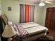 Bedroom with a spacious bed, hardwood flooring, and window with curtains at 7316 Truelight Church Rd, Mint Hill, NC 28227